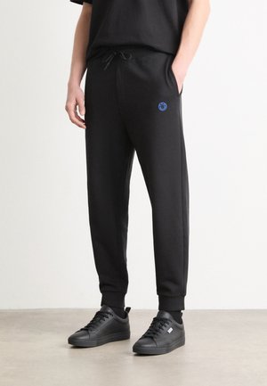NOMPIO - Tracksuit bottoms - black