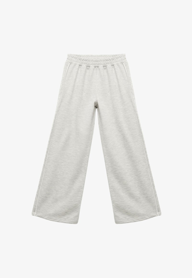 Grå, vide sweatpants lavet af blødt stof, med elastisk talje og kontrasterende hvid kant langs hver ben.