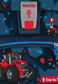 Blauwe stoffen rugzak met een tractor ontwerp, rode accenten en een textuur-knopsluiting met het 'Step by Step' logo. De ritssluiting heeft ook een tractor-thema.