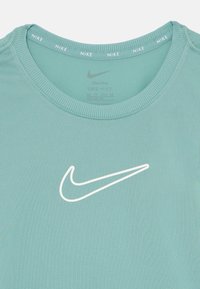 T-shirt Nike Dri-FIT turquoise clair avec un col rond et un logo swoosh blanc à l'avant. Texture lisse, design ajusté et col côtelé.