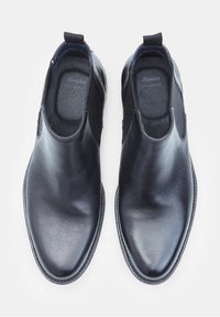 Černé kožené nazouvací boty s hladkým povrchem, elastickými bočními panely a zaobleným designem špičky. Vnitřní podšívka obsahuje šedé polstrování.