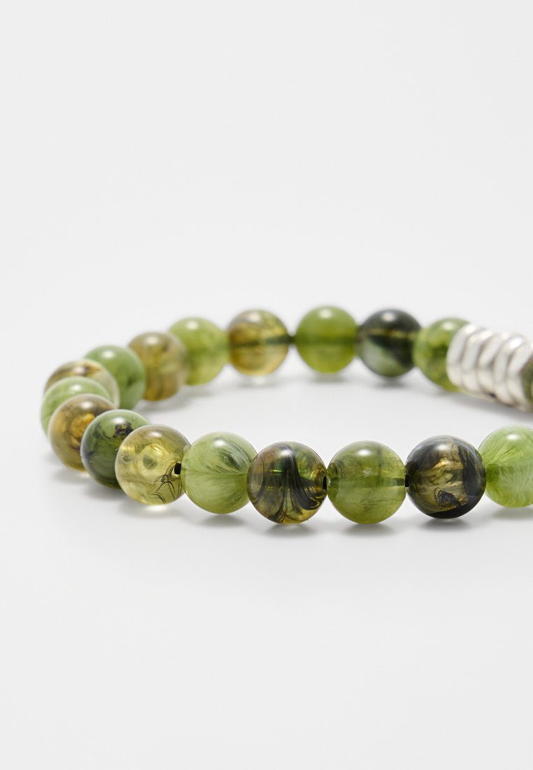 Bracciale di perline verde con sfumature e texture variabili. Le perline rotonde presentano motivi translucidi e marmorizzati, accentuati da uno spacer in argento.