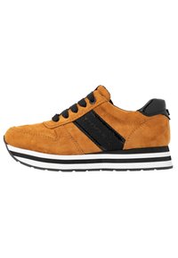 Zapatillas de ante marrón con acentos negros, que presentan una franja lateral texturizada, cordones negros y una suela de rayas blancas y negras.