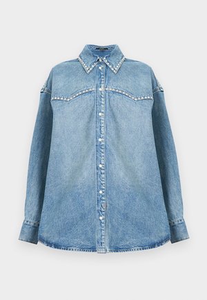 Svijetloplava traper košulja s dugim rukavima, okovratnikom i sedlom ukrašenim perlama, gumbima zatvaranje sprijeda i ravnim rubom na bijeloj pozadini.