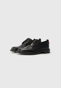 Black leather shoes with a smooth finish, featuring a lace-up design, rounded toe, and subtle red accents on the heel.