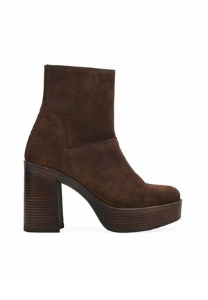 Botín de ante marrón oscuro con tacón alto y grueso apilado, y suela de plataforma, vista lateral sobre fondo blanco.