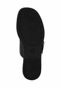 La suola della scarpa nera presenta un motivo di grip testurizzato con un bordo liscio. Logo del marchio e indicazione della taglia visibili sul lato inferiore.