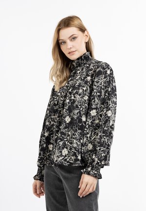 Bluză cu model floral în culori negru și crem, cu guler și manșete volănele. Fabricată dintr-un material ușor, având o croială lejeră și mâneci lungi.