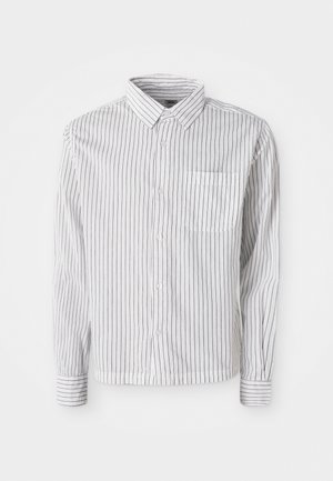 Bijela košulja dugih rukava s dugmadi, s crnim okomitim prugama i lijevim džepom na prsima, položena ravno na bijeloj pozadini.