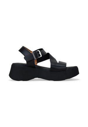 Sandalias de plataforma negras con tacón cuadrado, que presentan tiras cruzadas y una hebilla lateral. El material parece suave con un acabado mate.