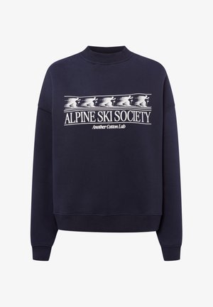 Marineblaues Sweatshirt mit Rundhalsausschnitt und weißem Aufdruck von fünf Skifahrern, Schriftzug "ALPINE SKI SOCIETY" und kleinerem "Another Cotton Lab" darunter.