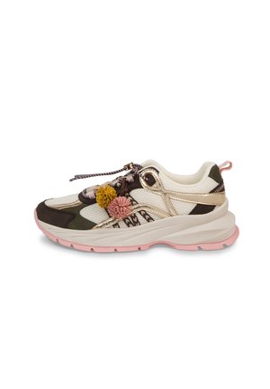 Stevige sneaker in roomkleur, roze en olijfgroen met metalen gouden accenten en decoratieve gele en roze pompons op patroonveters.