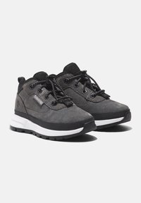 Black and gray hiking shoes with suede and mesh material, featuring round laces, a cushioned sole, and logo detailing on the side.