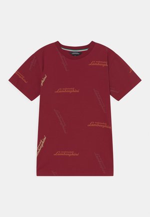 Hnědočervené tričko s krátkým rukávem s opakujícími se logy "automobili Lamborghini" v tlumených žlutých a oranžových tónech po celé látce.