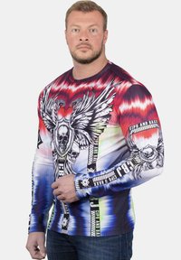 Langärmliges Shirt mit einem Farbverlauf in Rot, Blau und Weiß, verziert mit Grafiken von Schädeln und Flügeln sowie Logo-Akzenten. Hergestellt aus dehnbarem Stoff.