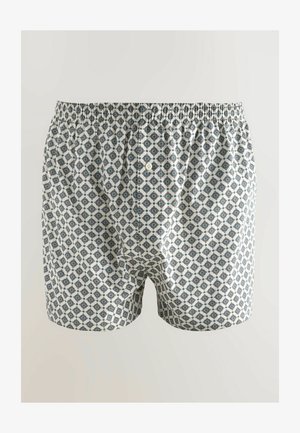 Kergedest puuvillased bokserid valge alusega, mis on kaunistatud geomeetrilise mustriga tumesinises ja tealas. Neil on elastne vöökoht ja nööpidega lend.