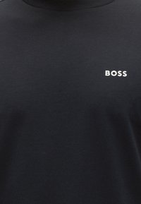 Must crewneck-t särk valge "BOSS" tekstilogoga ülemisel vasakul rinnal, lihtsa ja paksu kirjatüübiga.