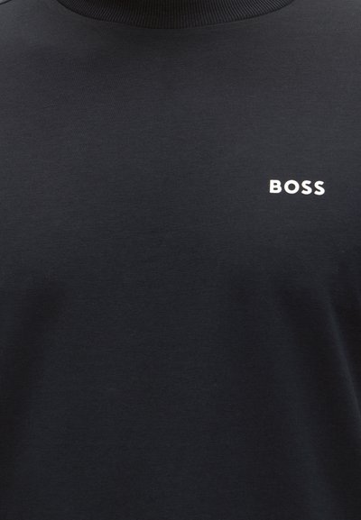 T-shirt noir col rond avec logo texte blanc "BOSS" sur la partie supérieure gauche de la poitrine, en police simple et grasse.