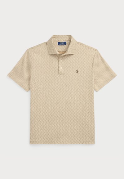 Bež majica polo s kratkimi rokavi, z zapenjanjem na tri gumbe in ponavljajočim se geometrijskim vzorcem. Ima vezeno logo na prsih.