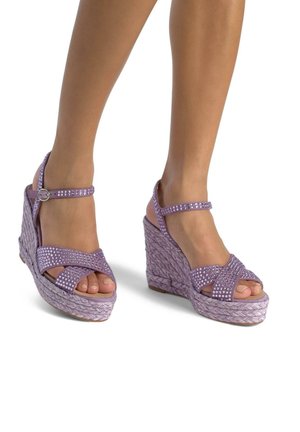 Le sandali a cuneo viola presentano cinturini incrociati glitterati, una cinghia alla caviglia regolabile e un materiale che ricorda il juta intrecciato. Design open-toe.