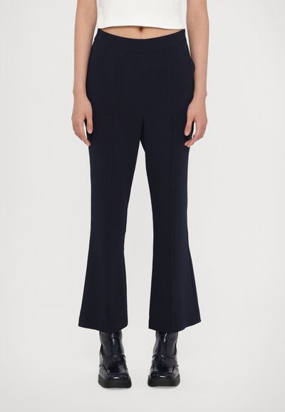 Pantaloni vaporați bleumarin dintr-un material elastic, cu buzunare frontale și talie înaltă. Asortați cu botine negre cu toc pentru contrast.