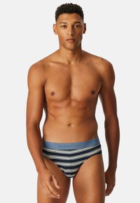 Slip da uomo in navy con strisce orizzontali bianche e azzurro chiaro. Tessuto morbido, vita elastica con logo "SCHIESSER" in azzurro chiaro.