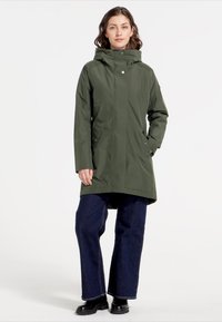 Lang, gewatteerde jas van donkergroene stof, met een ritssluiting aan de voorkant, drukknoopsluiting en zijzakken. Casual pasvorm met een rechte snit.