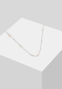Sølv kæd necklace med skiftende hvide perler i forskellige størrelser. Har glatte teksturer og et delikat, minimalistisk design.