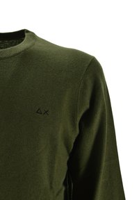 Olijfgroene lange mouw crew neck sweater met kleine zwarte geborduurde driehoek en X-symbolen op de linkerkant van de borst.