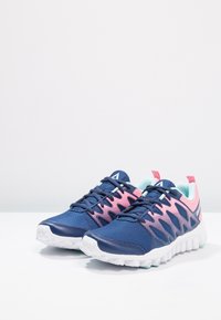 Blå och rosa sportskor med ovandel i mesh, texturerad design, vit sula och turkosa accenter. Har snören och dragflik bak.