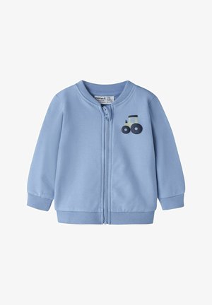 Light blue zip-up jacket made of soft fabric, featuring ribbed cuffs and hem. Includes a printed tractor graphic on the front.