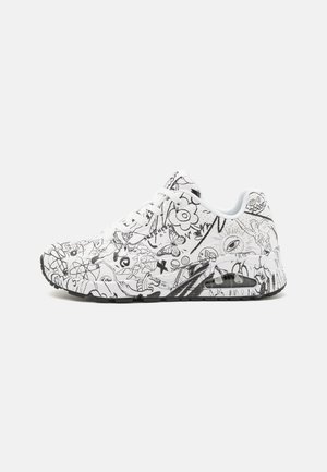 White sneakers featuring black abstract doodles, lace-up design, padded collar, and a black rubber outsole with a visible air unit.