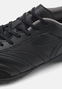 Schwarzer Lederturnschuh mit texturiertem Finish, kontrastierenden grauen Akzenten und einer Schnürung mit verstärkter Naht.