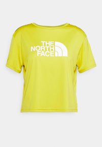 Żółta koszulka z krótkim rękawem, uszyta z gładkiego, lekkiego materiału, z dużym białym logo "THE NORTH FACE" na przodzie.