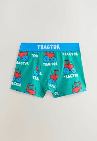 Boxers verts pour garçons avec imprimés de tracteurs rouges et bleus et texte "TRACTOR" sur la ceinture et le motif du tissu.