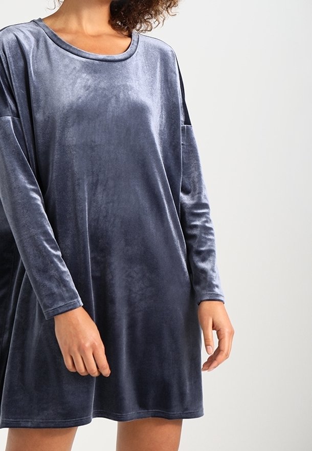 Sammetklänning i mörkgrått, med långa ärmar, lös passform och bred ringning, tillverkad av ett mjukt, slätt tyg.