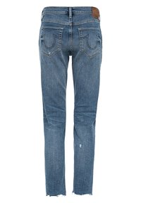 Niebieskie dżinsy z prostym krojem, z przetarciami i brązową skórzaną łatą na tylnej części pasa. Nity na kieszeniach.