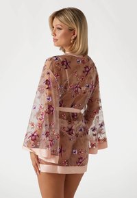 Doorzichtig bloemenkant badjas met belmouwen, voorzien van een roze satijnen rand en intrigerende borduursels in paarse en roze tinten. Vast te strikken in de taille.