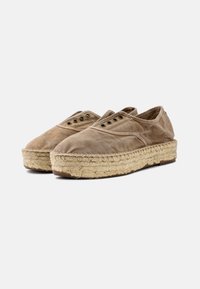 Beige espadrillok vászon felsőrésszel, kerek orral, megerősített varrásokkal, két szett fűzőlyukkal és jutekötésű talppal.