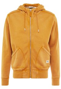 Sudadera amarilla con cremallera y acabado texturizado, dos bolsillos frontales, puños acanalados y capucha con cordón. Presenta un pequeño logo en el dobladillo inferior.