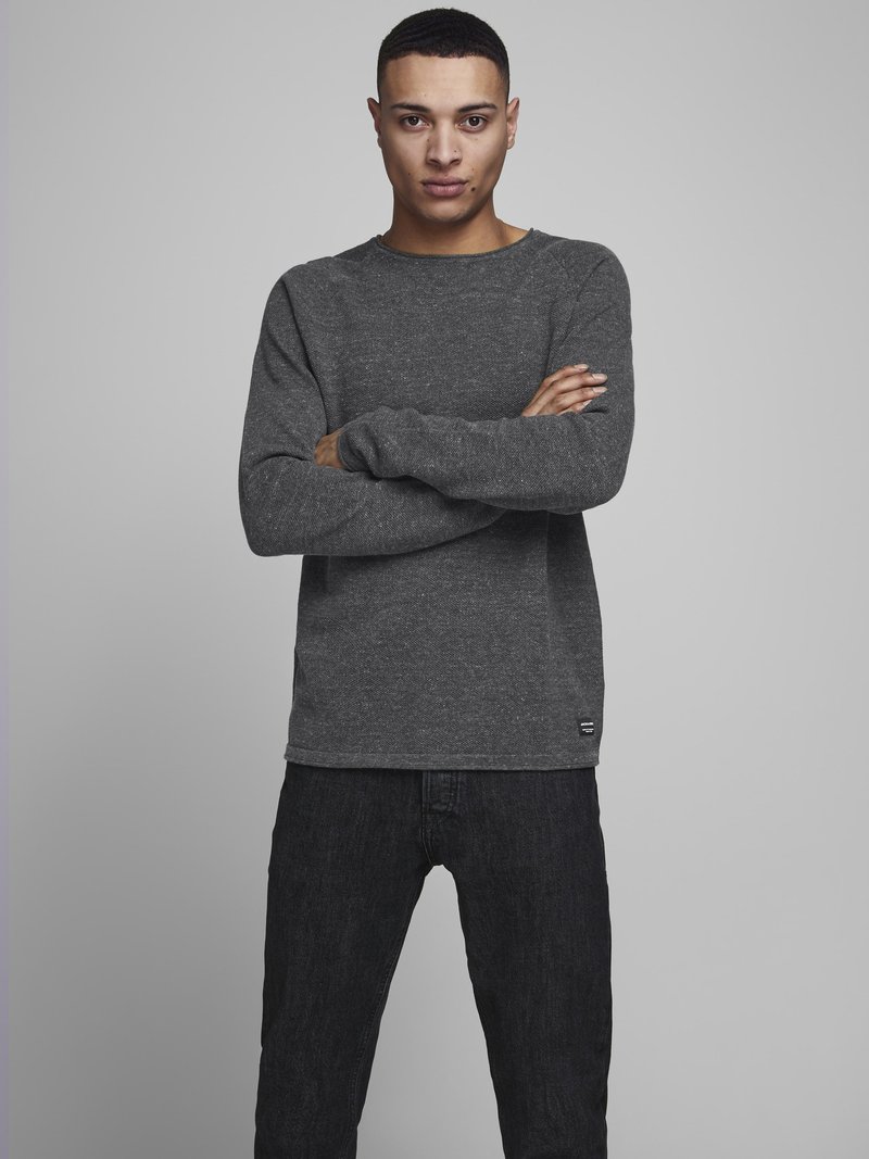 Men's mørkegrå langermet genser i strukturert stoff, rund hals, med brettede mansjetter, parret med mørke jeans.