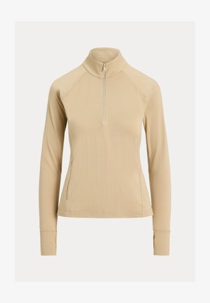 Beige langærmet damesweater med kvart lynlås, høj krave, tommelhul og lynlåslomme på venstre side.