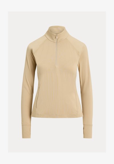 Μπεζ γυναικείο πουλόβερ με μακριά μανίκια, φερμουάρ στο ένα τέταρτο μήκους, ψηλό γιακά, οπές για τους αντίχειρες και τσέπη με φερμουάρ στην αριστερή πλευρά.