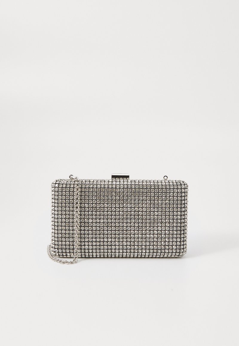 Torba za ruke prekrivena srebrnim rhinestones, pravokutnog oblika, metalna kopča za zatvaranje i lančana naramenica. Glatka tekstura sa reflektirajućom završnom obradom.