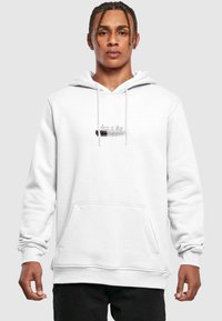 Sudadera blanca con capucha, con un bolsillo canguro, puños acanalados y un gráfico bordado a la altura del pecho. Textura de felpa suave.