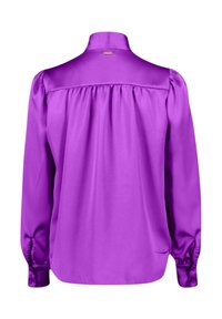 Blusa di raso viola con colletto alto, maniche lunghe a sbuffo e schiena arricciata. Texture liscia; presenta un piccolo logo dorato sul collo.