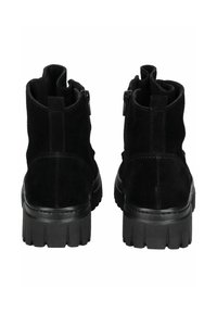 Bottines en suédine noire avec une semelle en caoutchouc épaisse, dotées d'une fermeture éclair sur le côté et d'un bout légèrement arrondi, conçues pour un enfilage facile.