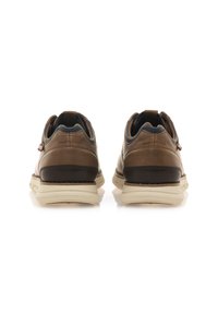 Zapatillas de cuero marrón con acentos marrones oscuros, superficie texturizada y suela de goma blanca. Presenta un collar acolchado y una tira en el talón.