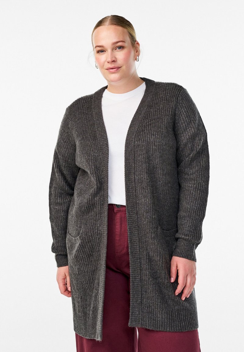 Tmavo šedý rebrovaný cardigan s dlhými rukávmi, otvoreným frontom a dvoma prednými vreckami, skombinovaný s bielym topom a bordovými nohavicami.