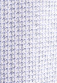 Tessuto intrecciato con un motivo testurizzato in un design a zigzag viola chiaro e bianco. Leggera lucentezza con una finitura liscia.